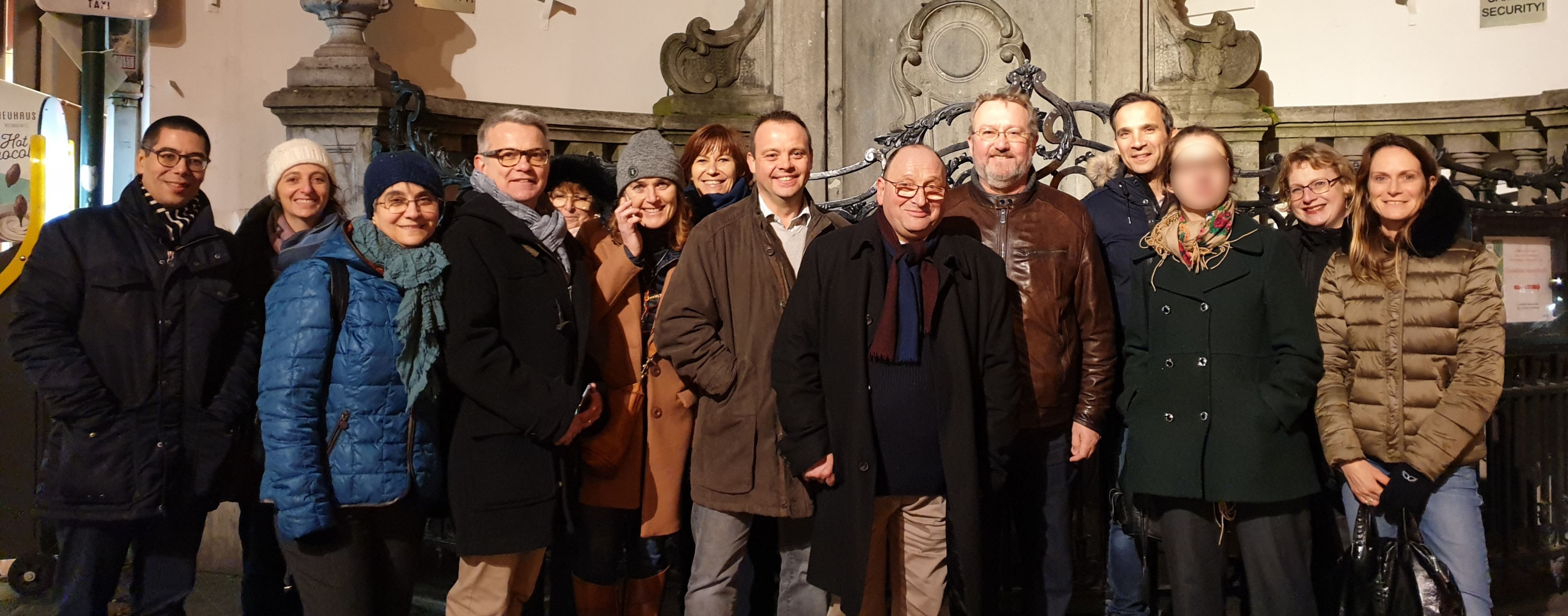 Un large groupe de personne prenant la pose devant la Manneken Pis