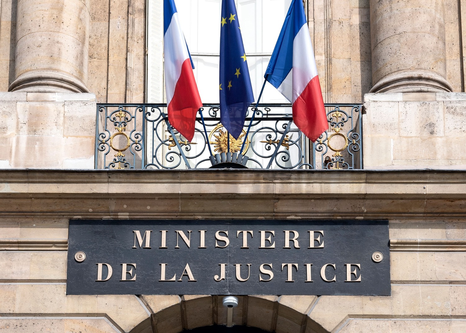 Photo du fronton du Ministère de la Justice, où l'on voit également deux drapeaux français et le drapeau européen